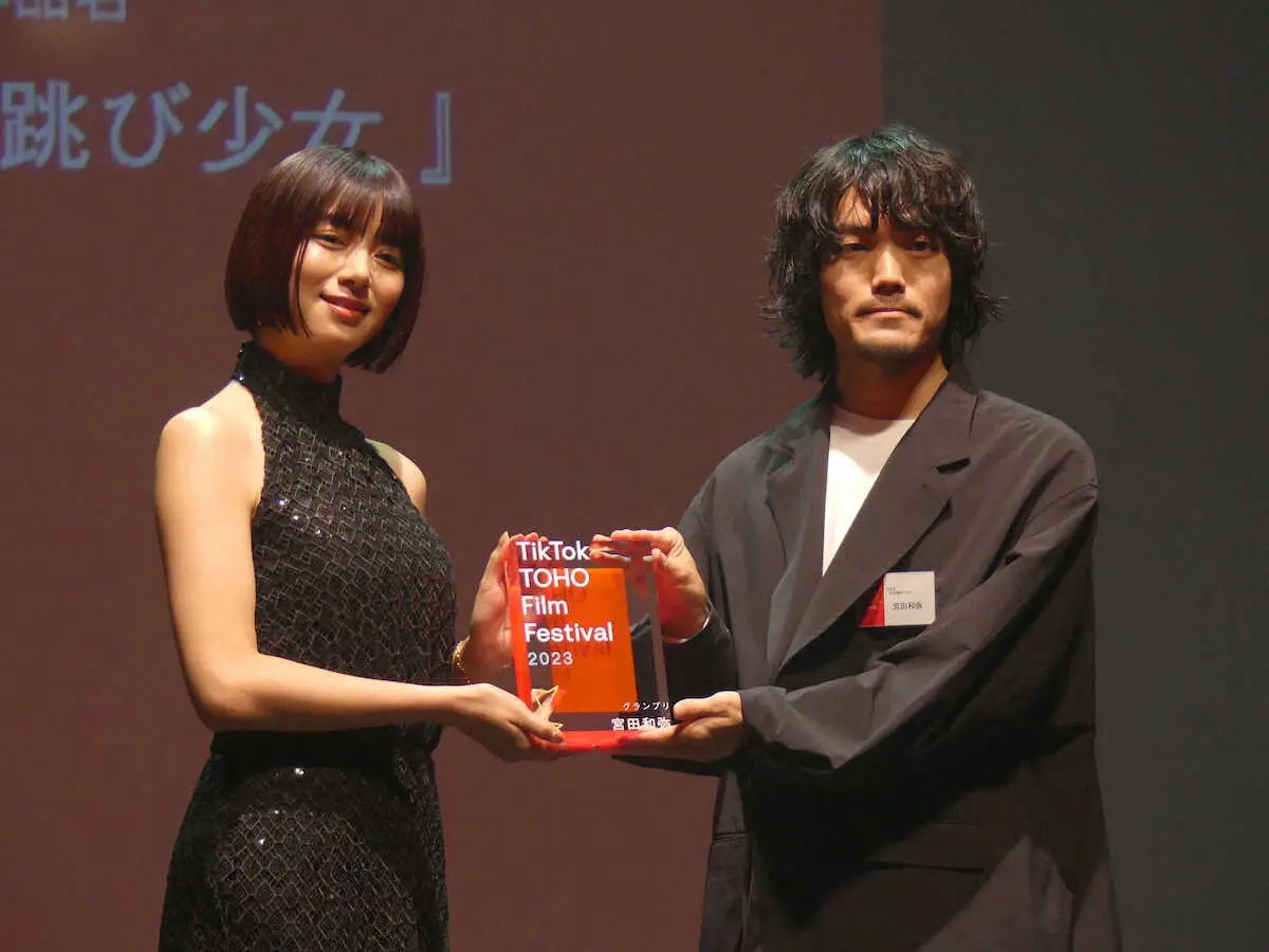 「TikTok　TOHO　Film　Festival　2023」でグランプリに輝いた宮田和弥さん（右）にトロフィーを手渡す池田エライザ