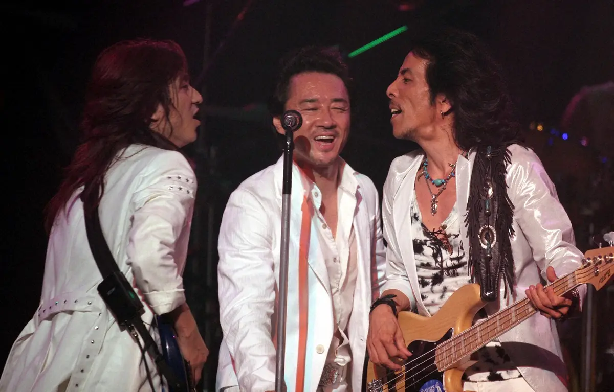 2005年、デビュー25周年を記念して行われたライブで熱唱する「ハウンドドッグ」の（左から）ギター・西山毅、ボーカル・大友康平、ベース・鮫島秀樹