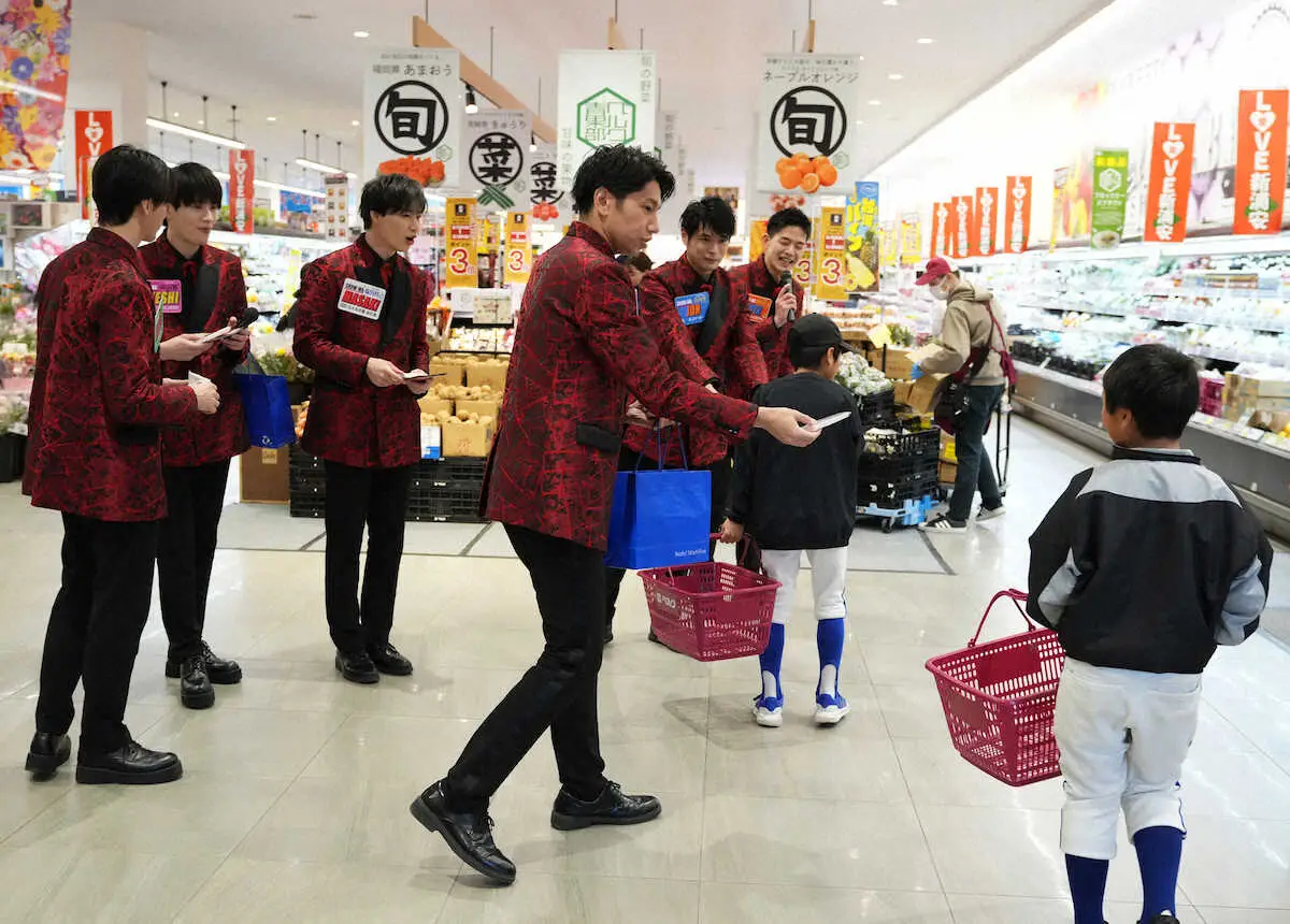 スーパーの生鮮食品売り場前でチラシを配る山本佳志らメンバー達（撮影・沢田　明徳）
