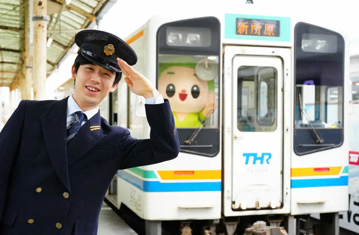 天竜浜名湖鉄道の掛川駅で車両を背に車掌姿で笑顔を見せる藤井聡太王将（2022年撮影）