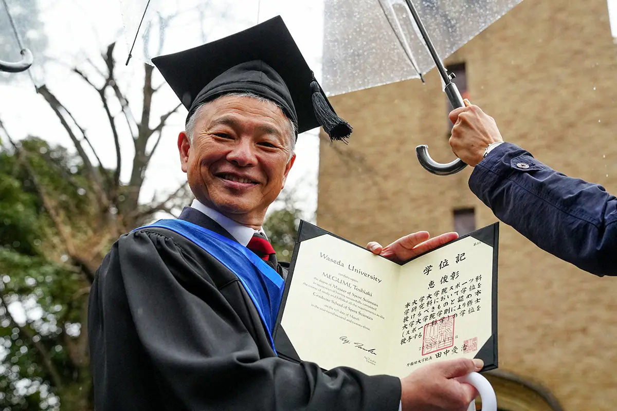 2023年3月、早大大学院学位授与式で学位記を手に笑顔を見せる恵俊彰