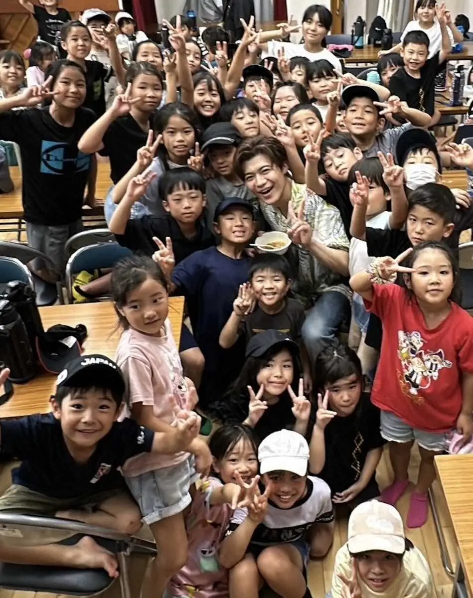 沖縄県うるま市の子供食堂で子どもたちにもみくちゃにされる新浜レオン（中央）