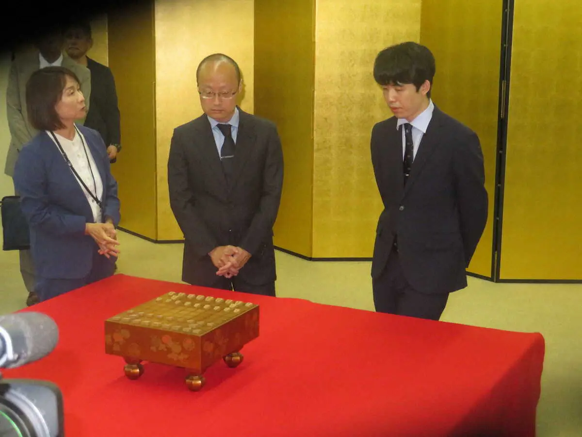 徳川美術館を訪問し、江戸時代の将棋盤に見入る藤井聡太王位（右）と渡辺明九段（中）