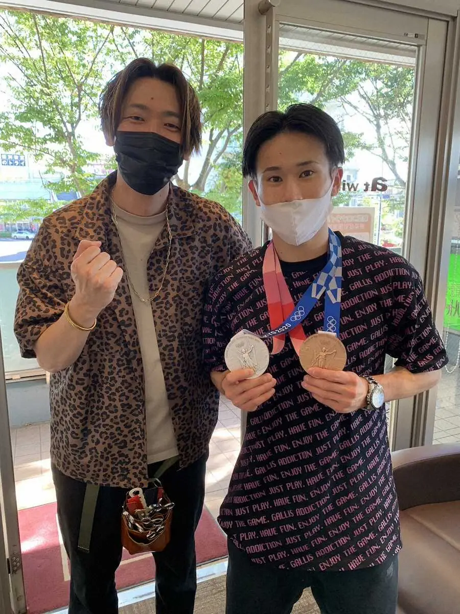 東京五輪のメダルを手にする萱和磨（右）と担当美容師の折笠善一さん