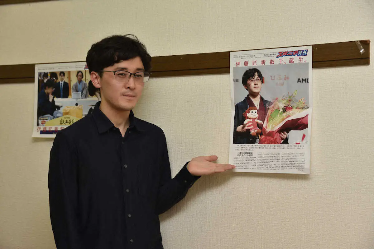 三軒茶屋将棋倶楽部に飾られたスポプリと写真を撮る将棋の伊藤匠叡王（撮影・小田切　葉月）