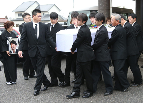 親族、関係者らの手によって斎場を出る後藤浩輝騎手の棺