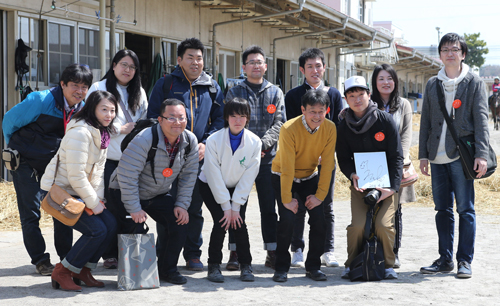 見学者と記念撮影する根本師（前列左から４人目）、藤田（前列左から３人目）