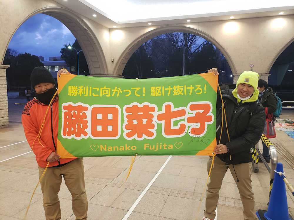 東京競馬場のパドックに掲げる菜七子横断幕を手にする佐々木信一さん（左）（撮影・小田　哲也）