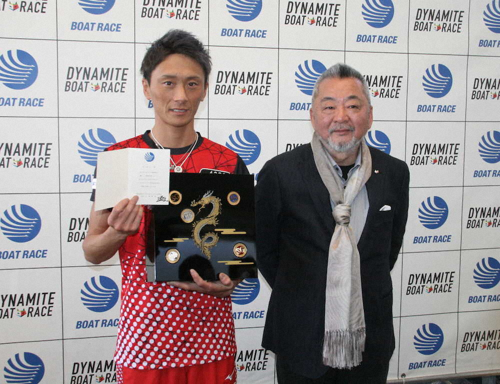 BOATRACE振興会の小高幹雄会長（右）からゴールデンレーサー賞表彰式への招待状とメダル収納用ディスプレイケースを贈呈された峰竜太