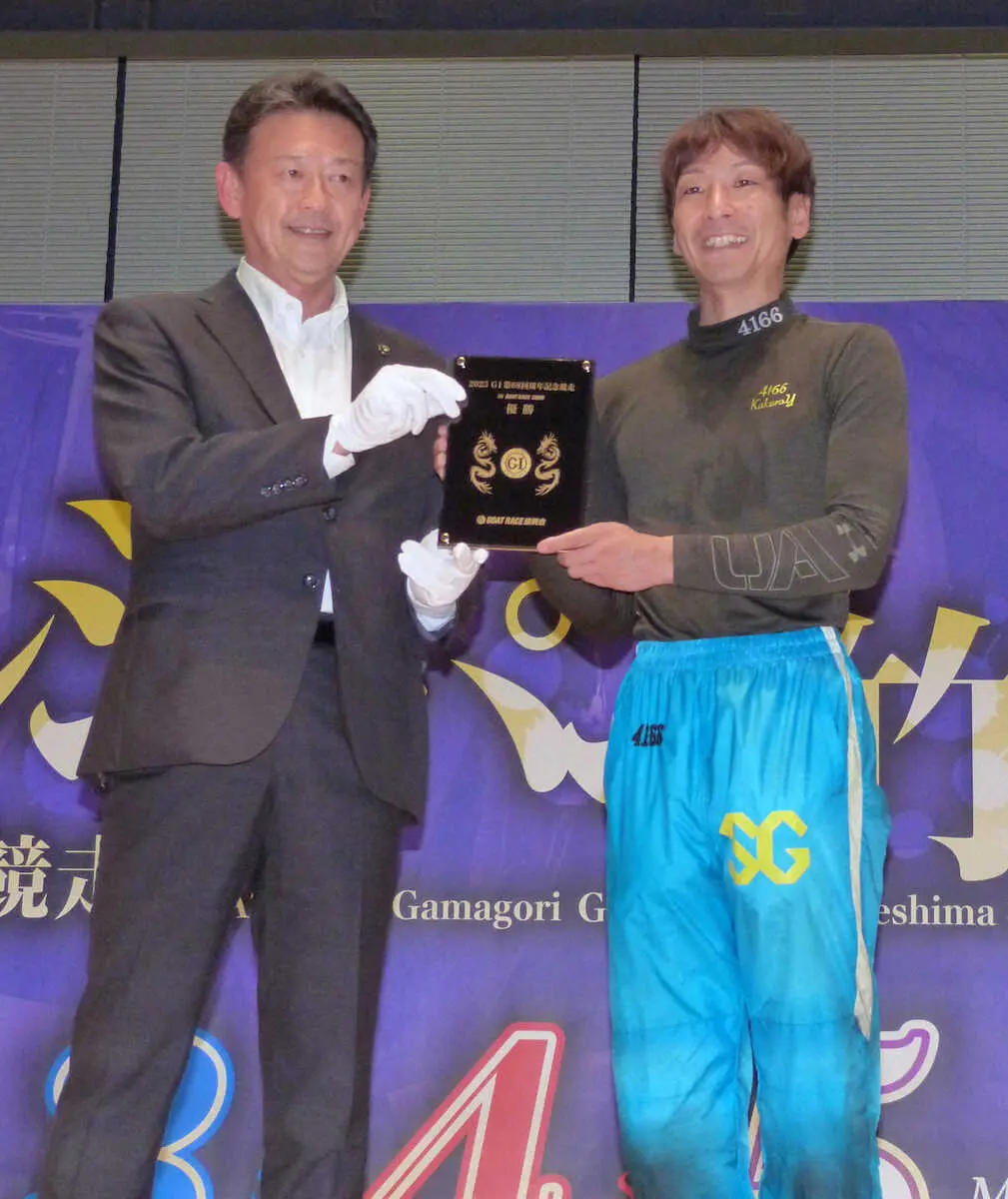 鈴木寿明蒲郡市長から純金メダルを受け取る吉田拡郎（右）