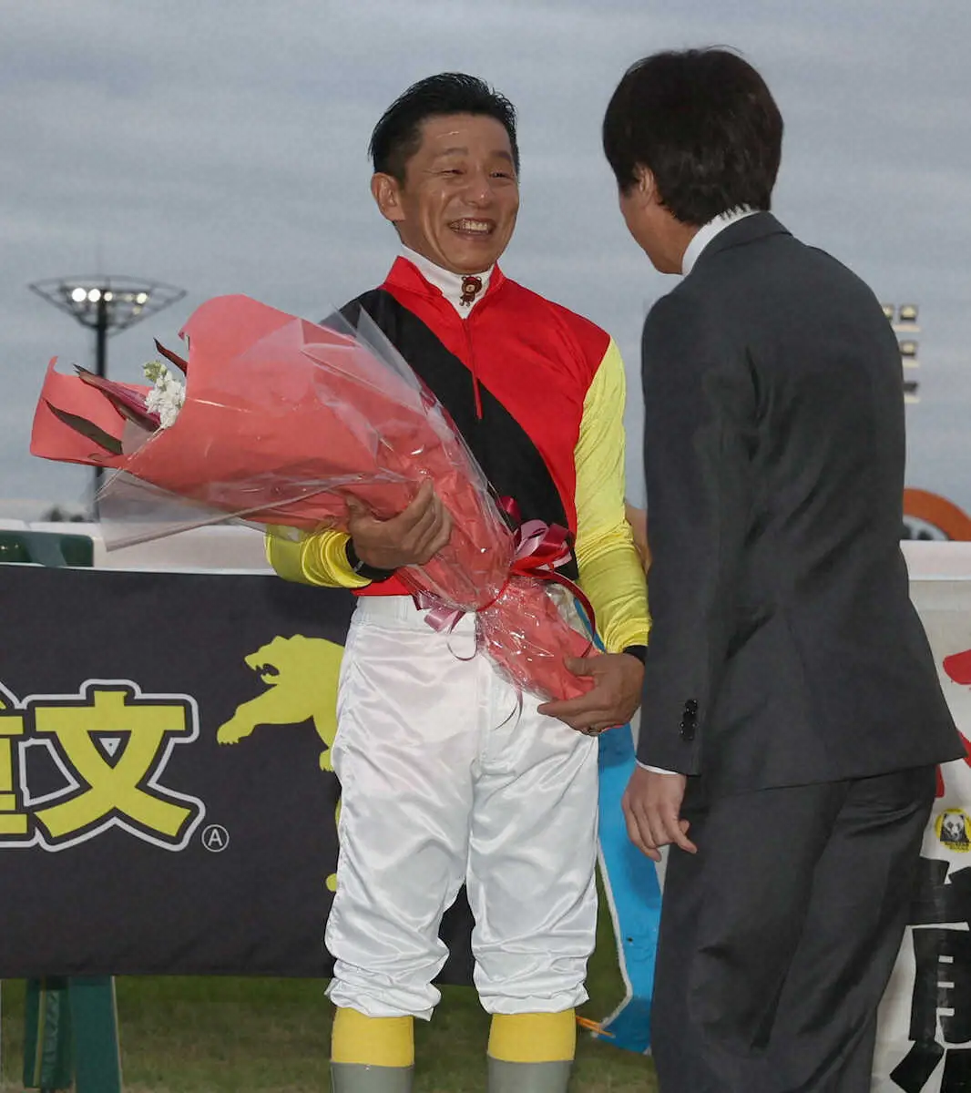 競馬学校同期の松永幹夫調教師から花束を受け取った熊沢（左）（撮影・亀井　直樹）