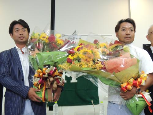 羽田着の航空機で帰国し、関係者から花束を贈られた池田勇太（左）と片山晋呉