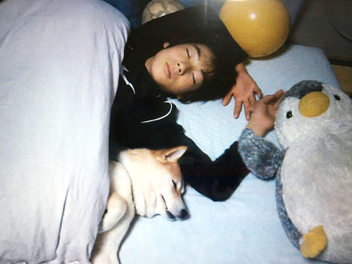ドリブル練習の相手をさせた飼い犬と一緒に眠る小学生時代の中島（母こずえさん提供）