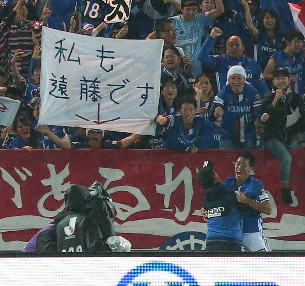＜横浜・鹿島＞後半、横浜・遠藤（右）がゴールを決め「私も遠藤です」という横断幕を掲げるサポーターの前で喜ぶ