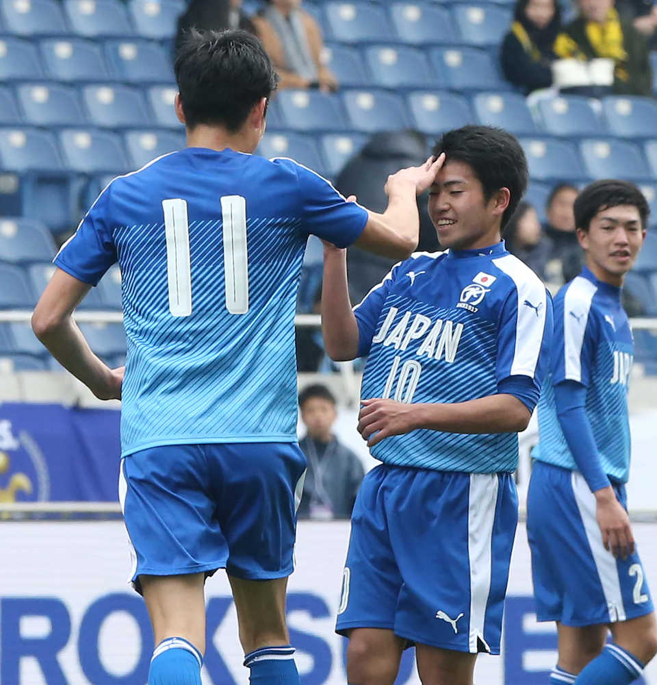 ＜Ｕ−１８Ｊリーグ選抜・日本高校サッカー選抜＞前半、ゴールを決めた日本高校サッカー選抜・飯島（中）は町野（左）の手荒い祝福を受ける。