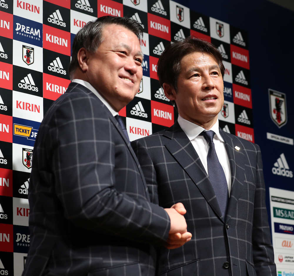 西野新監督（右）と笑顔で握手をする日本サッカー協会の田嶋会長