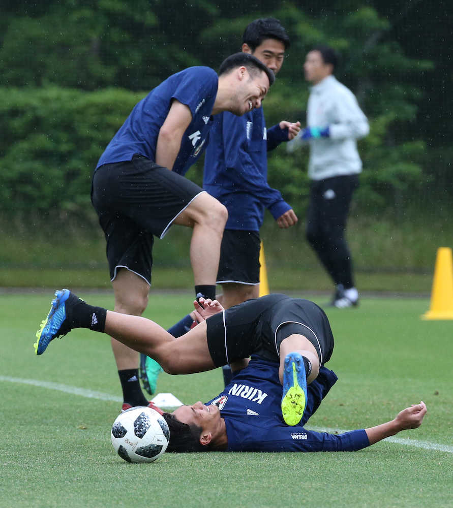 サッカー日本代表練習で転倒しながらも笑顔で汗を流す槙野（下）上は吉田麻也（撮影・西海健太郎）　