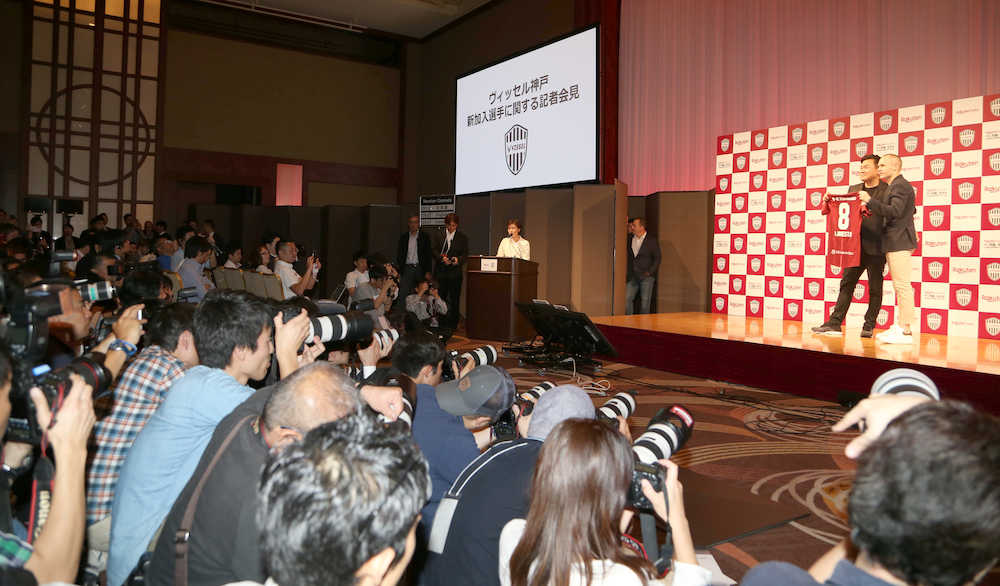 多くの報道陣が詰めかけた神戸入団会見で、三木谷会長とともにユニホームを披露するイニエスタ（撮影・田中　和也）