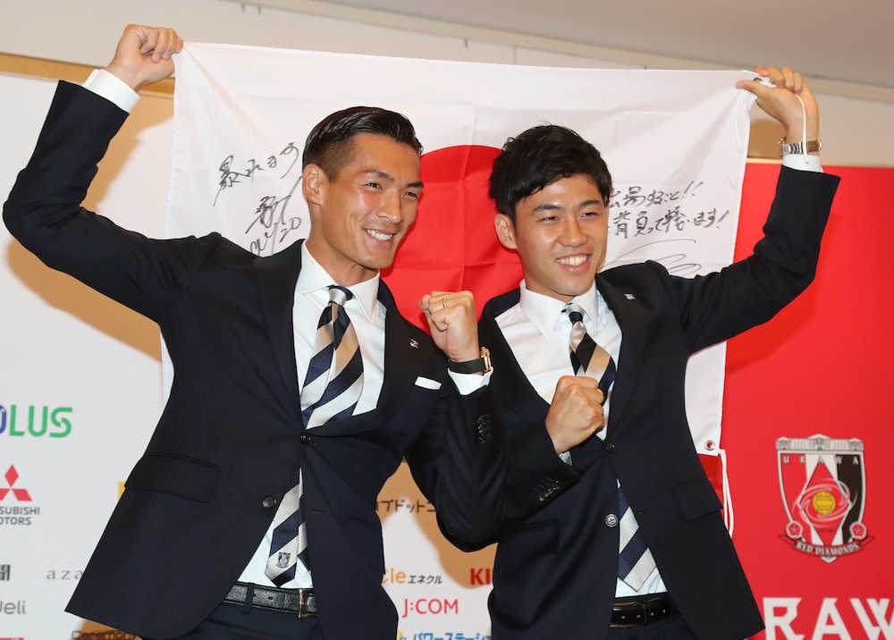浦和から選出された槙野（左）、遠藤は意気込みを書いた日の丸を手にガッツポーズする（撮影・沢田　明徳）