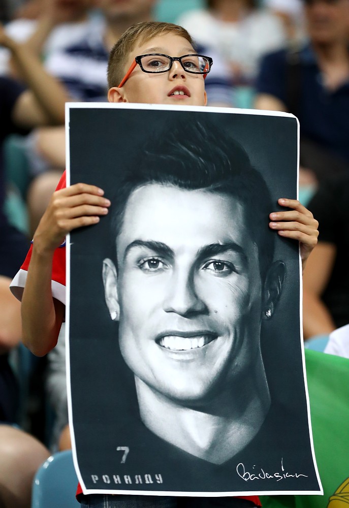 エースＣ・ロナウドのポスターを誇らしげに掲げるポルトガルの少年サポーター（ゲッティ）
