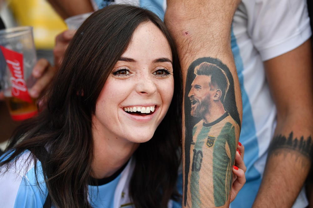 メッシのタトゥーに顔を寄せ、笑顔のアルゼンチンサポーター（ゲッティ）