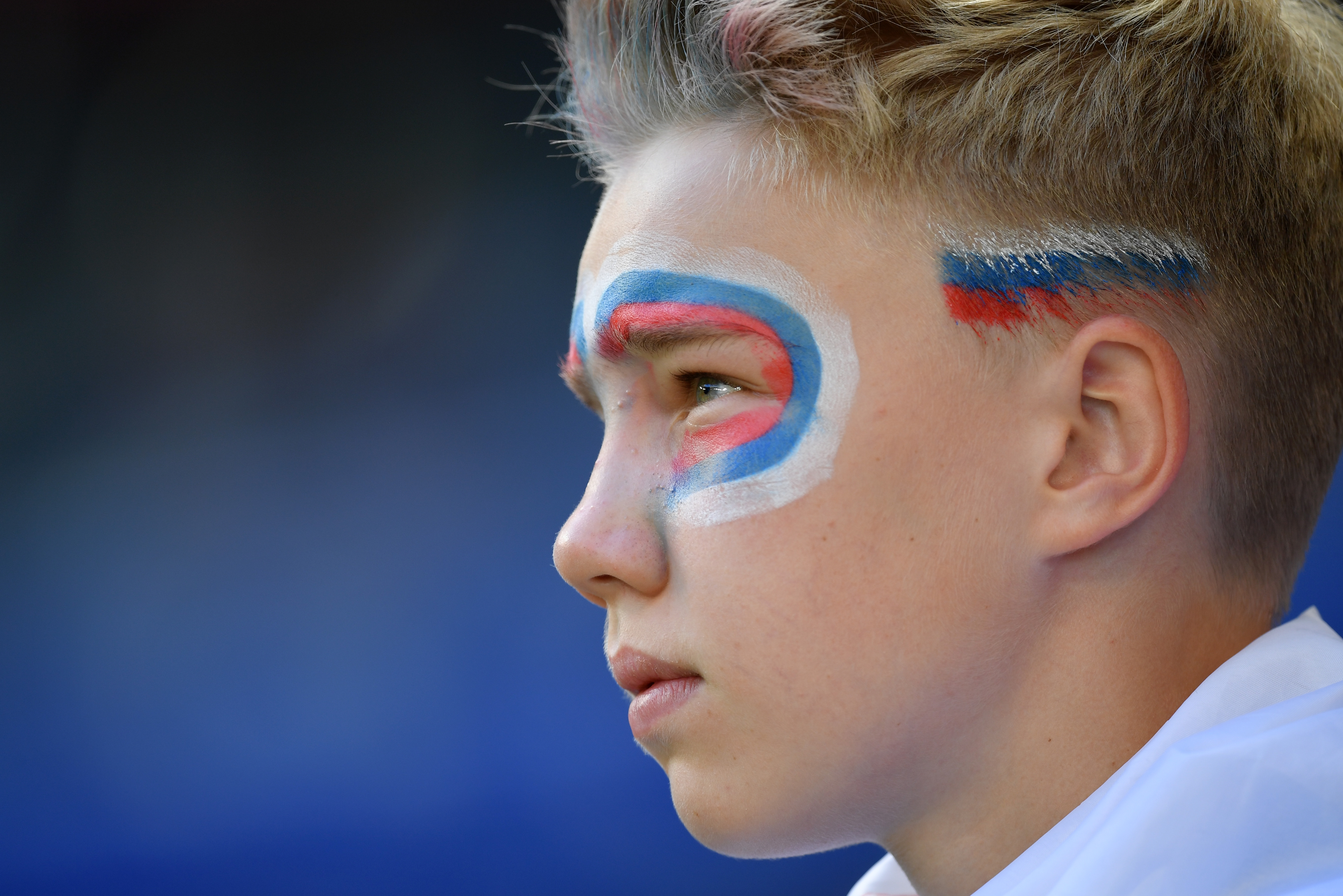 顔と前髪に国旗色をあしらい、コスタリカ―セルビア戦を見つめる少年（ゲッティ）