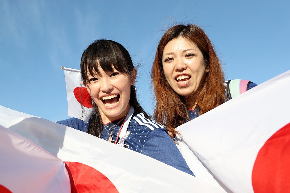 日の丸の国旗を手に笑顔の日本サポーター（ゲッティ）