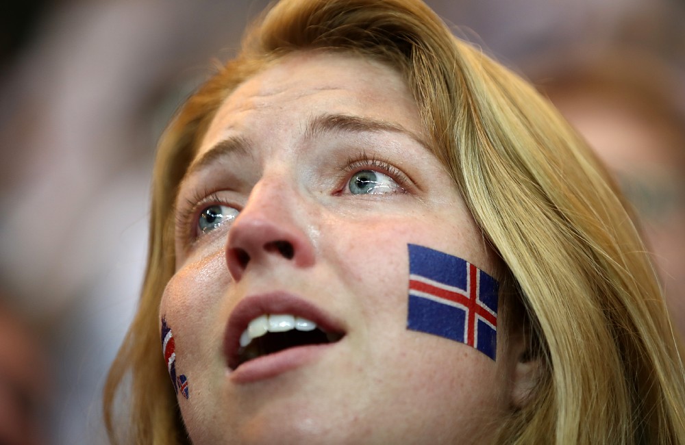 頬にアイスランド国旗のペインティングしたサポーターの目線の先は…（ゲッティ）