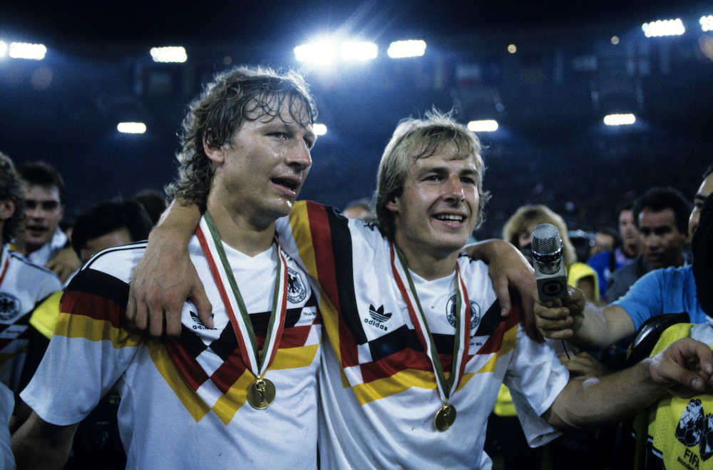 １９９０年のイタリアＷ杯で優勝し、健闘をたたえ合う西ドイツのブッフバルト（左）とクリンスマン
