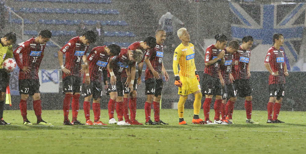降りしきる雨の中、悔しそうな札幌の選手たち