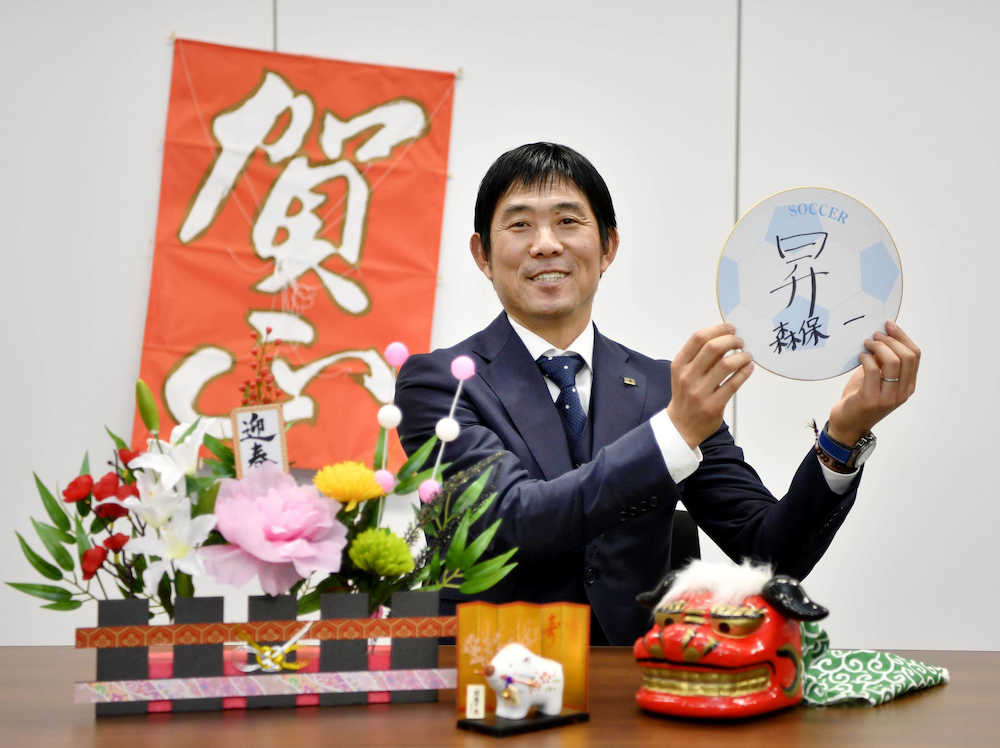 「昇」と書いた色紙を手に笑顔を見せる、日本代表の森保監督