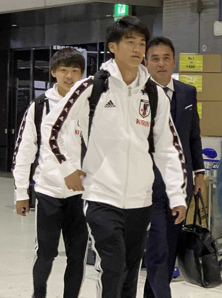 成田空港のチェックインカウンターに向かって歩く（左から）斉藤光、西川、影山監督