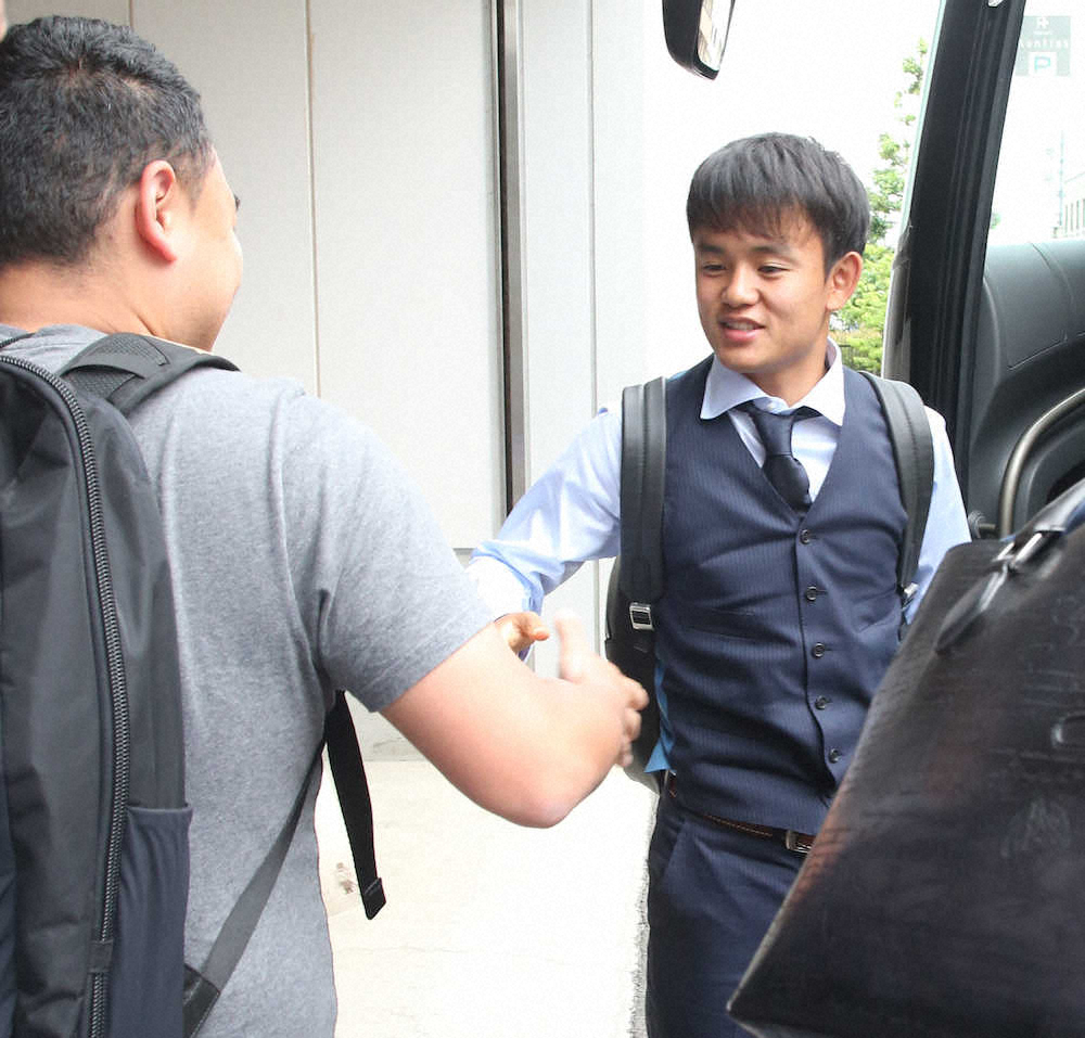 日本代表合宿の宿舎に到着しスタッフと握手する久保（撮影・西海健太郎）