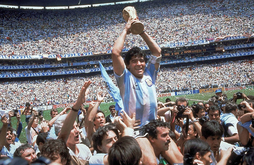 神の子天へ――。86年、W杯メキシコ大会で優勝し、チームメート担ぎ上げられ、ワールドカップを掲げるアルゼンチン代表のMFマラドーナ氏（中央）（AP）