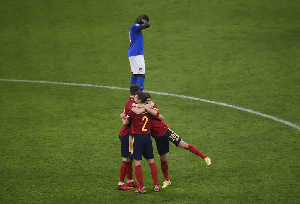 欧州ネーションズリーグ準決勝で勝利に歓喜するスペインイレブンの後ろで頭を抱えるイタリア選手（AP）