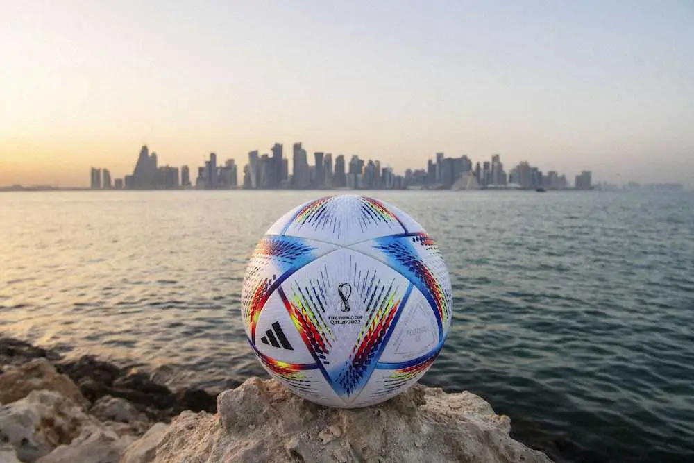 サッカーW杯カタール大会の公式球とドーハの街並み（ゲッティ＝共同）