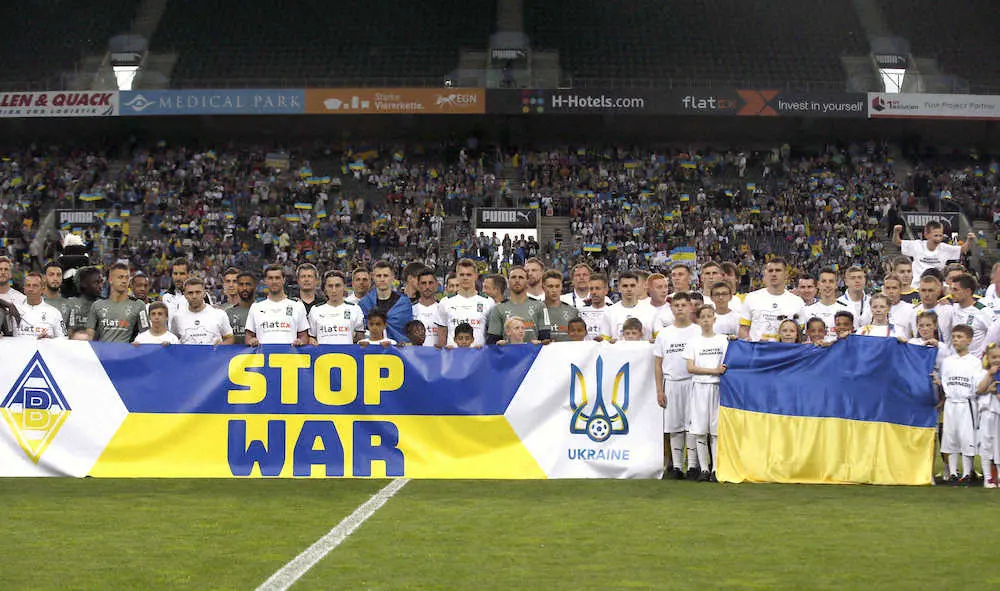 「STOP　WAR」と書かれた横断幕を掲げるウクライナ代表選手ら（ロイター）