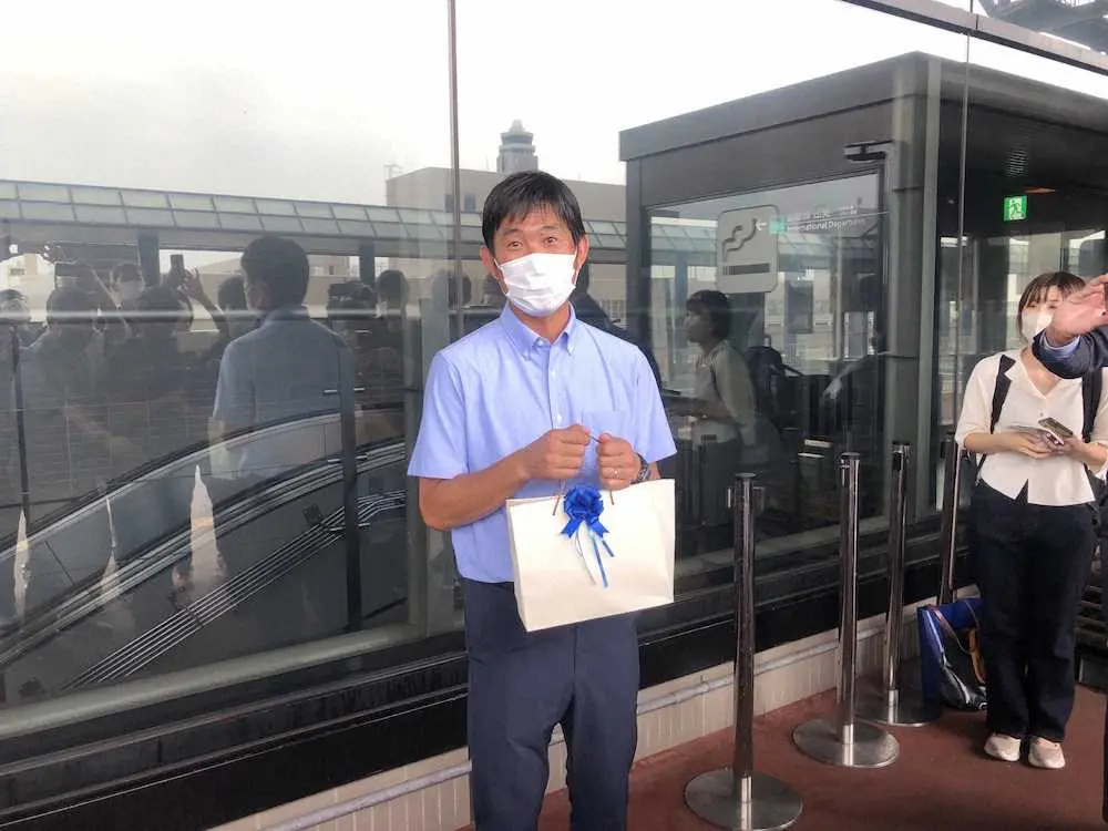 渡欧前の成田空港で報道陣から誕生日プレゼントを送られ笑顔の森保監督