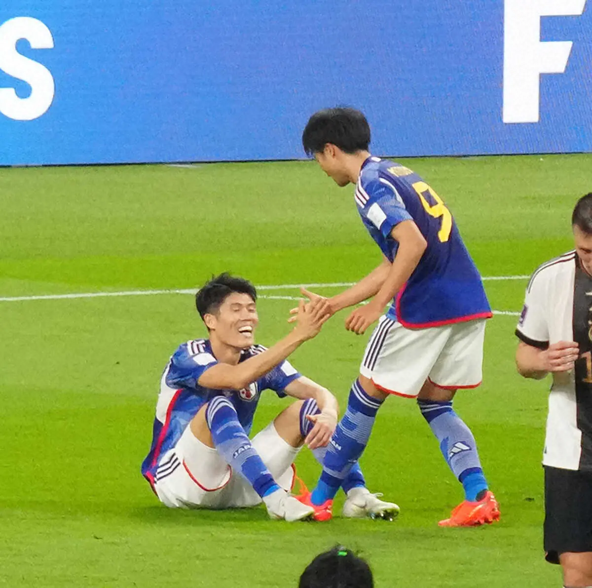 ＜日本・ドイツ＞試合後、ピッチに座り込んでいた冨安（左）は座ったまま三笘と勝利を喜ぶ（撮影・西海健太郎）