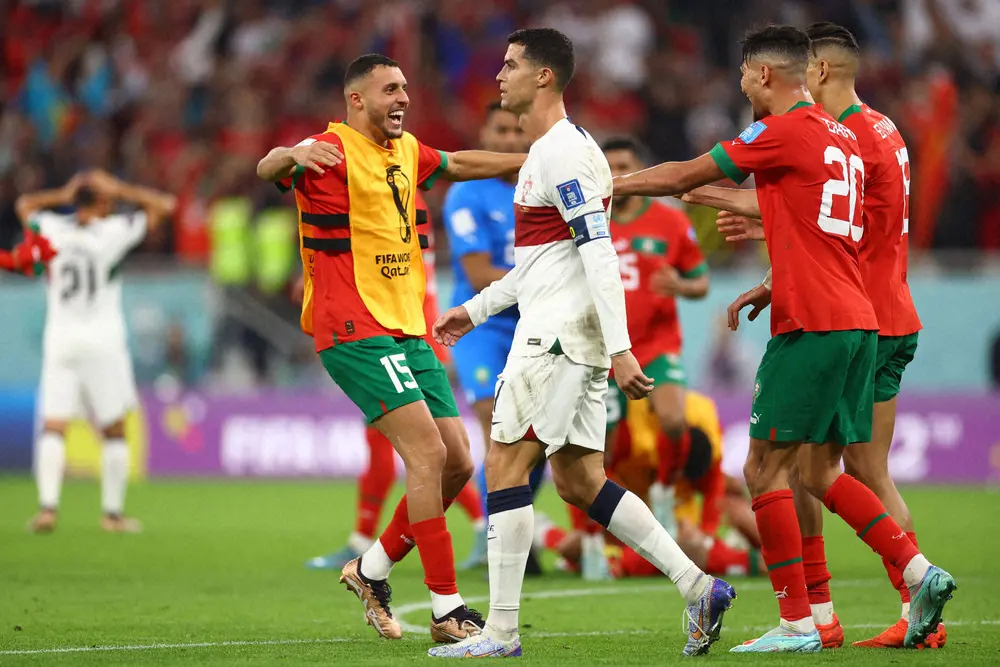 ＜モロッコ・ポルトガル＞準決勝進出を決め喜ぶモロッコ代表イレブン。中央は肩を落とすポルトガル代表C・ロナウド（ロイター）