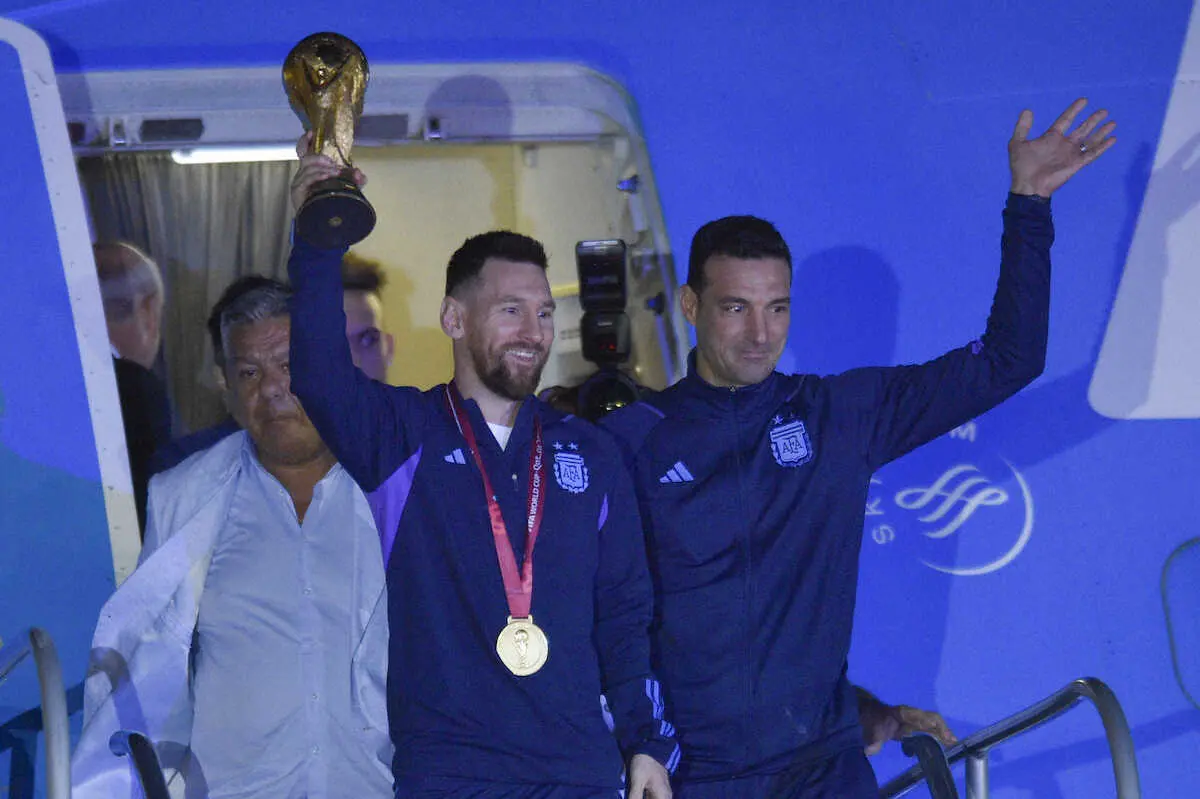 首位ブエノスアイレスに到着。ワールドカップトロフィーを手に笑顔のメッシ（AP）