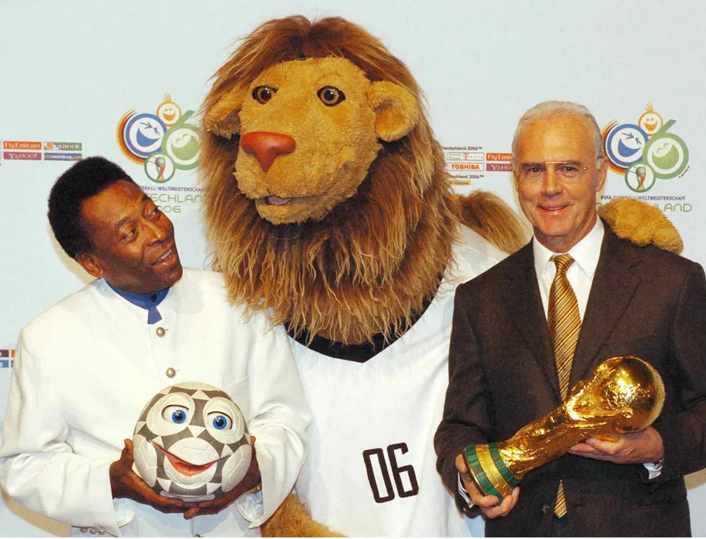 06年ワールドカップドイツ大会の公式マスコット「ゴレオ（GOLEO）」と笑顔で並ぶ、Ｗ杯組織委員長のフランツ・ベッケンバウアー氏（右）と元ブラジル代表ＦＷペレ氏（AP）