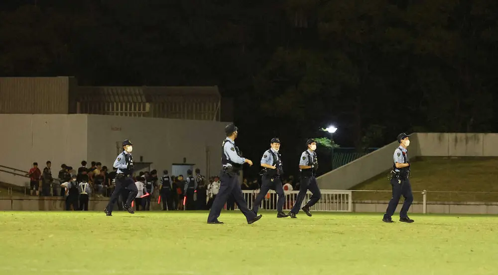 ＜天皇杯　名古屋・浦和＞試合後、浦和サポーターを背に忙しくピッチを走る警察官たち