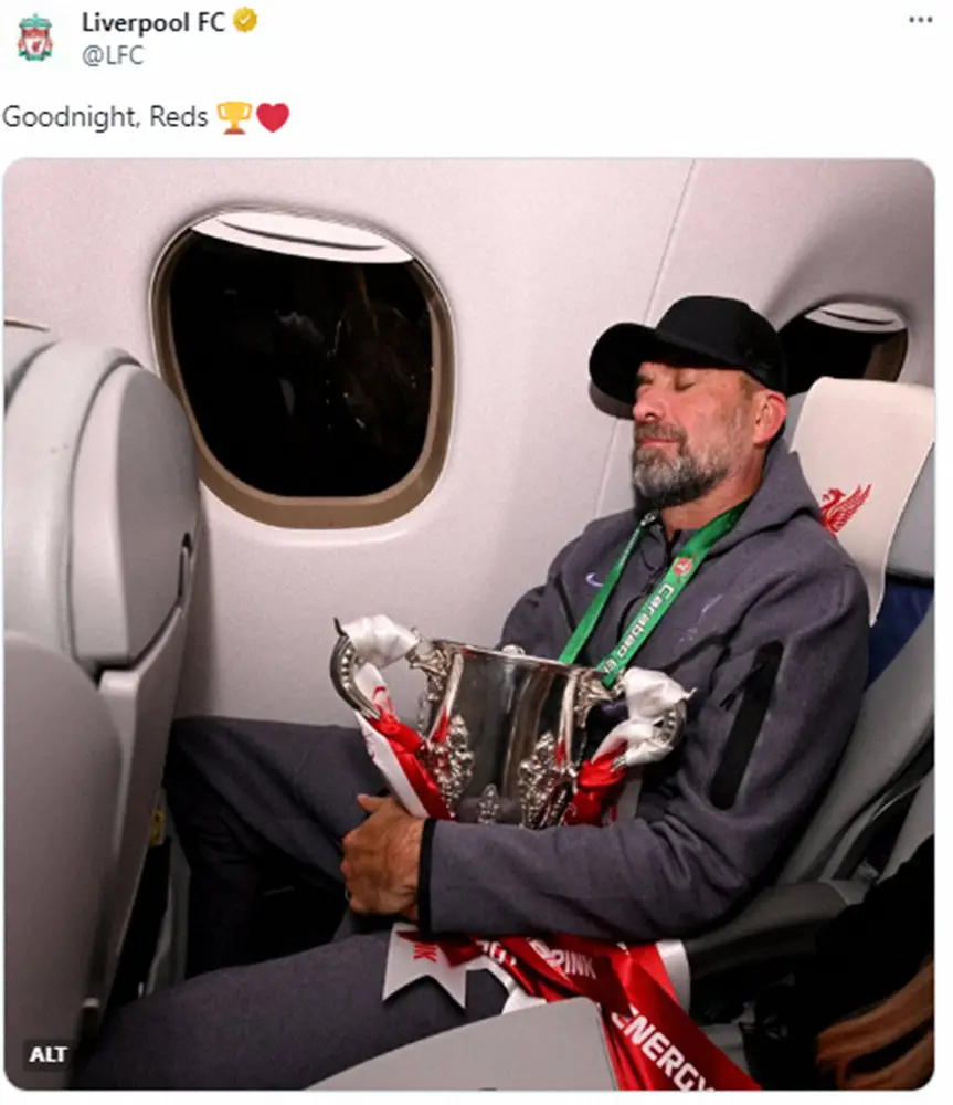 リバプール公式X（@LFC）から。イングランドリーグ杯優勝トロフィーを抱えて機内でぐっすり眠るクロップ監督