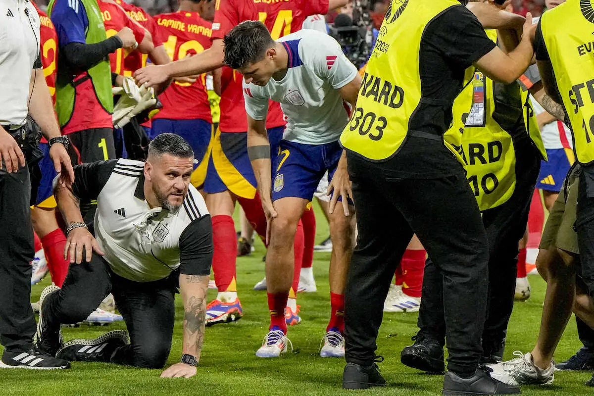 ＜欧州選手権　スペイン・フランス＞試合終了後、乱入したファンを止めようとした警備員を接触し右膝付近を痛がるスペイン代表モラタ（中央）（ロイター）