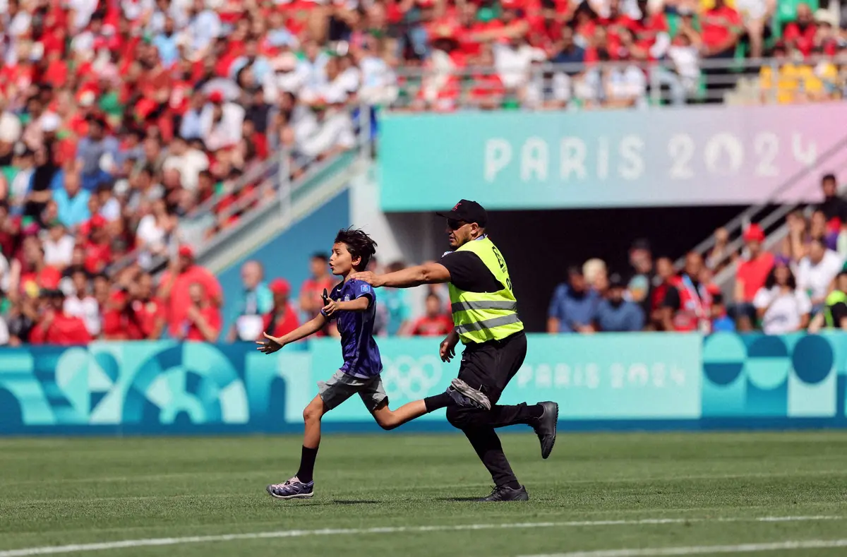 ＜パリ五輪男子サッカー　アルゼンチン・モロッコ＞試合中に乱入したサポーターを追いかける警備スタッフ（ロイター）
