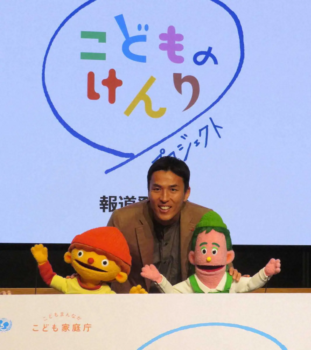 「こどものけんりプロジェクト」のキャラクターとして発表されたジーン（手前左）、ケーンとともにプロジェクトをPRする長谷部氏