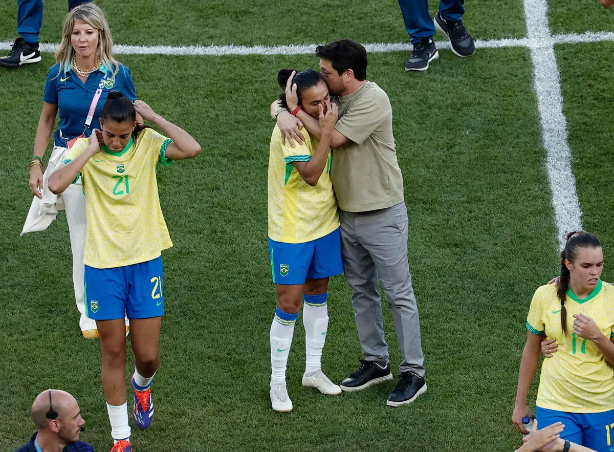 ＜パリ五輪サッカー女子　ブラジル・米国＞準優勝に終わり試合後、エリアス監督（中央右）から優しく抱きしめられるブラジル代表マルタ（ロイター）