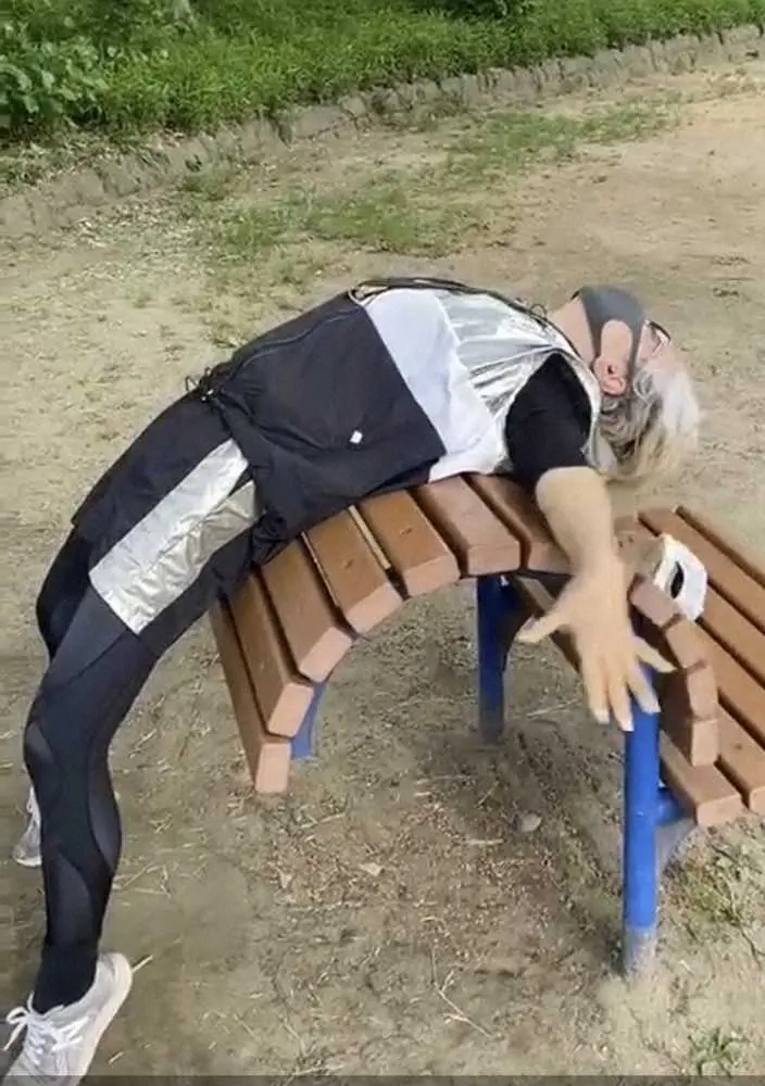 公園のベンチを使ってストレッチする中尾ミエ