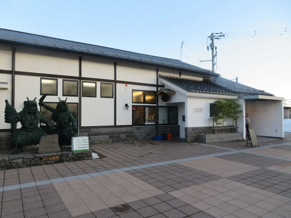 旧男鹿駅の駅舎をリノベーションした醸造所「稲とアガベ」。前にはなまはげの像が
